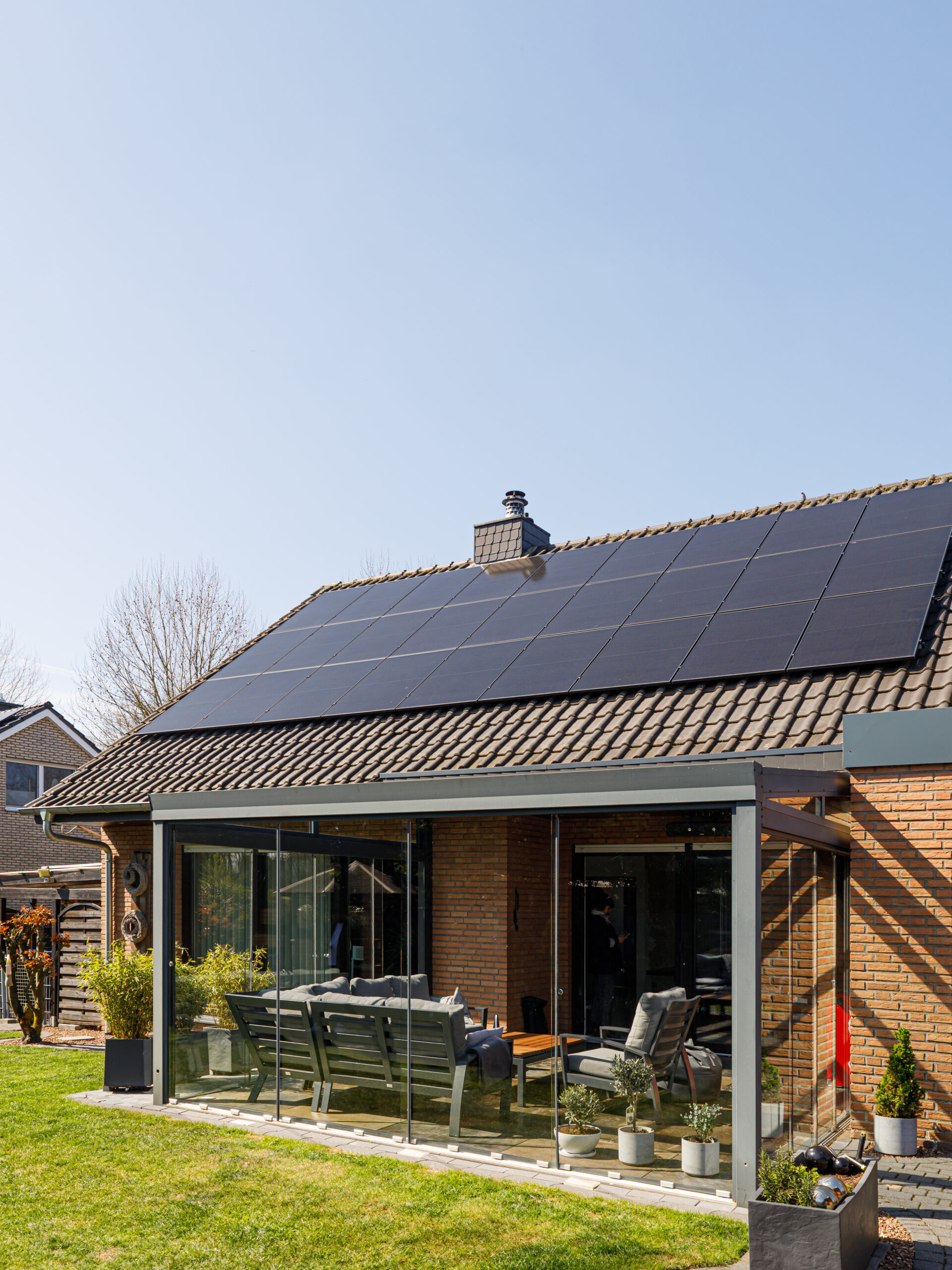 Bild eines Einfamilinehauses mit einer Solaranlage auf dem Dach. Die Photovoltaikanlage ist von Sigenergy mit Speicher oder Batterie einer DC-Wallbox und einer AC-Wallbox